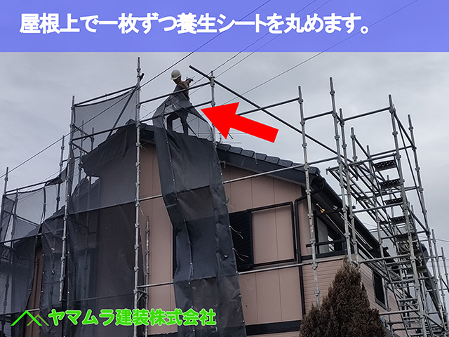 05.中川区 足場解体 屋根上で一枚ずつ養生シートを丸めます。